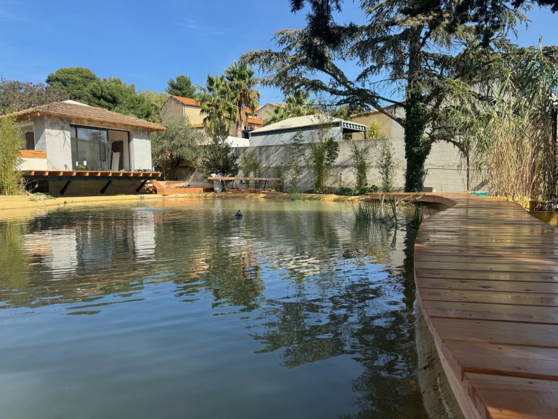 Pose artisanale de lames de bois autour d’un plan d’eau